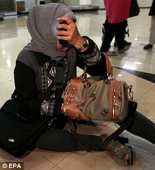 A relative of a passenger on the missing Sukhoi Superjet 100 aircraft cries as she is comforted after checking the passanger list at Halim Perdana Kusuma Airport in Jakarta, Indonesia